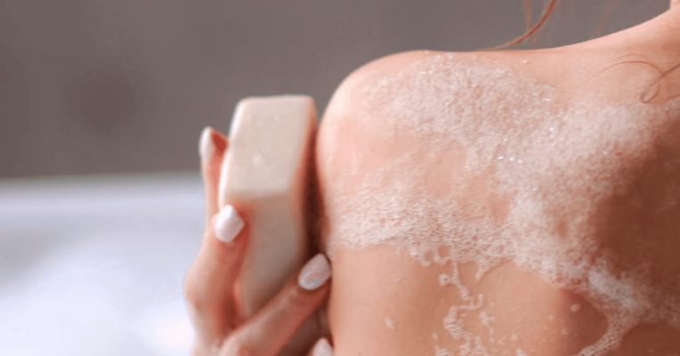 Une femme se lavant le corps à l'aide d'un savon au beurre de karité